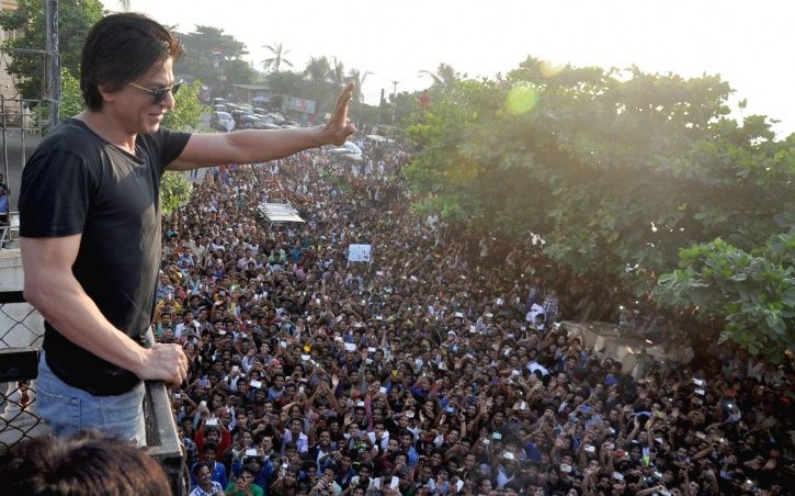 A picture of Shah Rukh Khan waving at his fans outside Mannat.