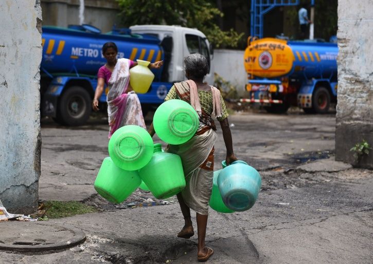 People filling water from a tanker in the situation of crisis.