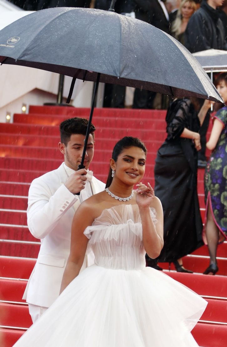Nick Jonas holds the umbrella for Priyanka Chopra at Cannes Film Festival 2019 red carpet.