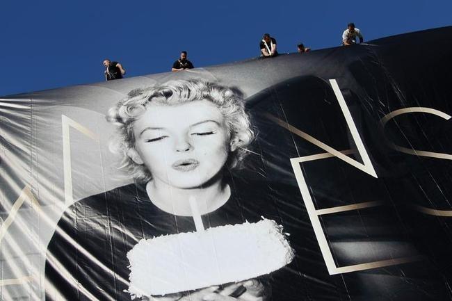 Workers set up a giant official poster of the 65th Cannes