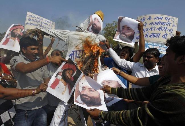 Demonstrators burn an effigy and posters of Narayan Sai, son of a Hindu guru popularly known as Asaram Bapu, to celebrate the arrest of Sai, in Ahmedabad