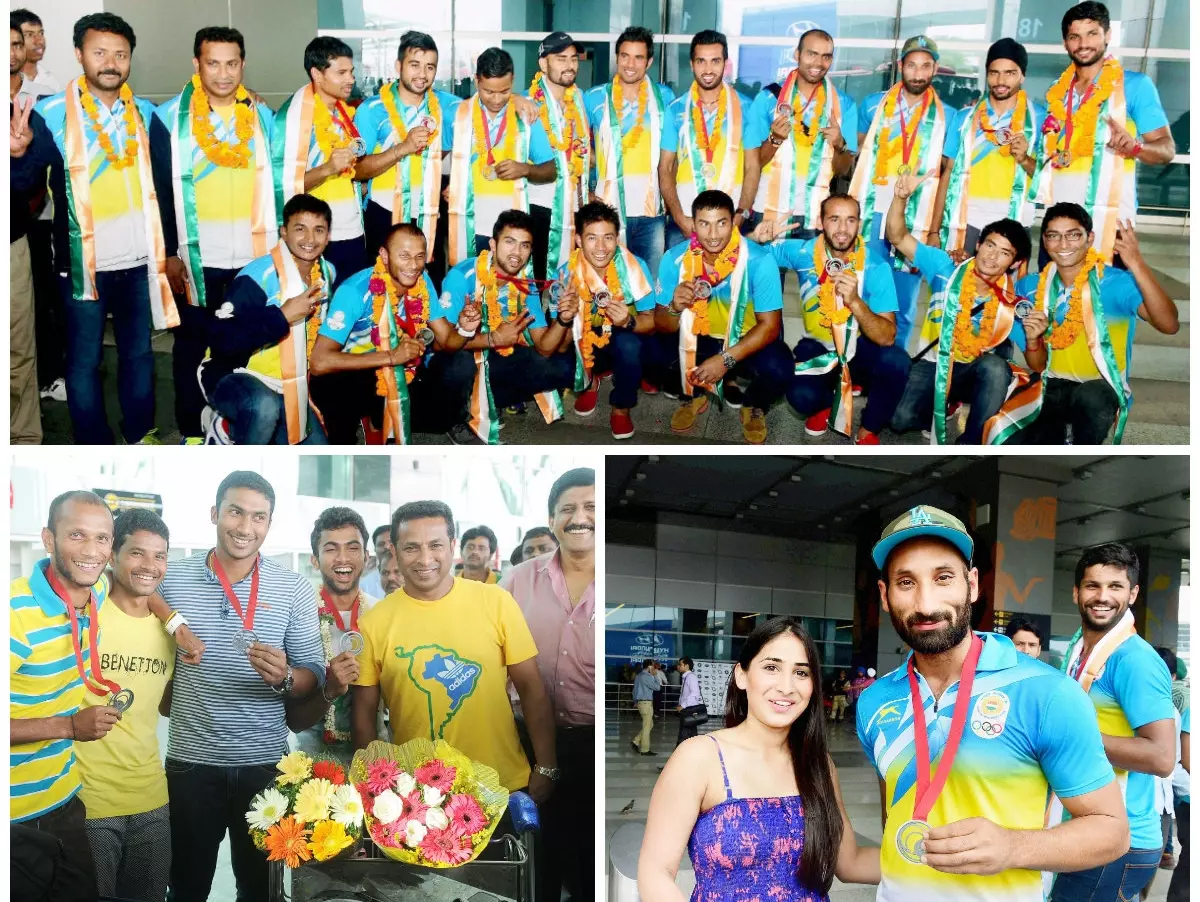 With a Commonwealth Games silver proudly hanging by their necks, the Indian men's hockey team returned home to a rousing welcome by Hockey India (HI), Indian Olympic Association (IOA), fans and friends at the Indira Gandhi International airport on Tuesday
