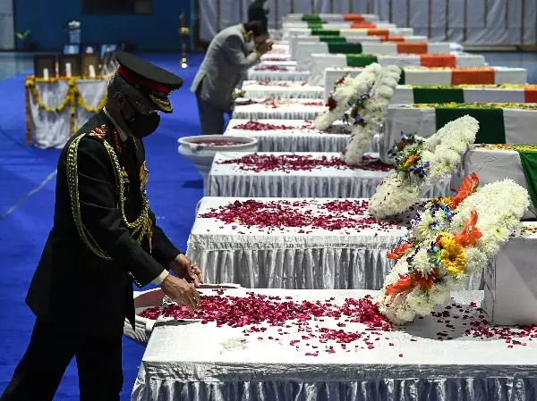India's Army General Manoj Mukund Naravane pays his tribute in front of the coffins containing the mortal remains of Chief of Defence Staff Gen Bipin Rawat and other 12 victims who lost their lives in a helicopter crash.