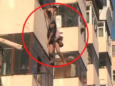 China: Fire-fighters rescue woman dangling from balcony